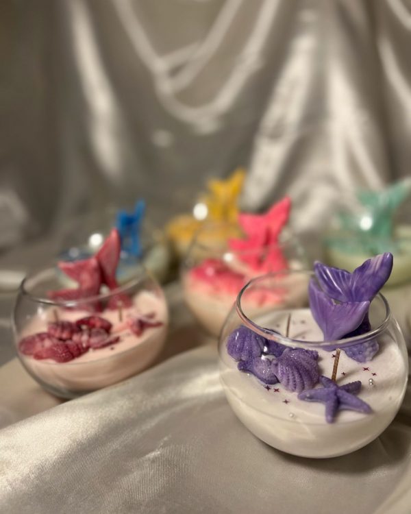 شموع معطرة داخل أكواب زجاجية مزينة بذيل حورية البحر وأشكال بحرية بألوان متعددة.