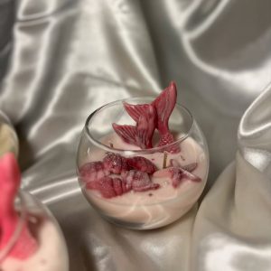 شموع معطرة داخل أكواب زجاجية مزينة بذيل حورية البحر وأشكال بحرية بألوان متعددة.